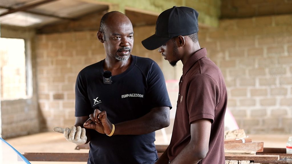 Deux hommes échangent près des installations, pendant le reportage sur la mouche soldat noire.